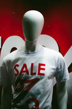 dummy on a shop window. White mannequin with an inscription on the chest t-shirts