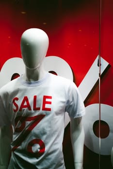 dummy on a shop window. White mannequin with an inscription on the chest t-shirts