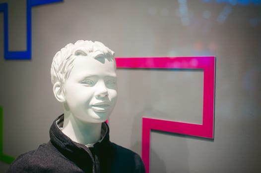 dummy on a shop window. Child face in the background of the store