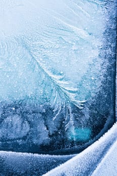 Iceflowers, frozen.The ice-cold frost forms ice crystals in beautiful unique patterns on the window, Hood and wiper on the Car