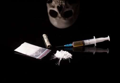 cocaine, Herion or other illegal drugs that are sniffed by means of a tube or injected with a syringe isolated on black glossy background