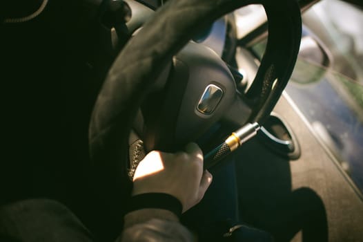 young vaper man with beard vaping mechanical mod. Guy smokes an electronic cigarette by blowing a smoke vapor. Holds in hand Sitting at the wheel of a car  background