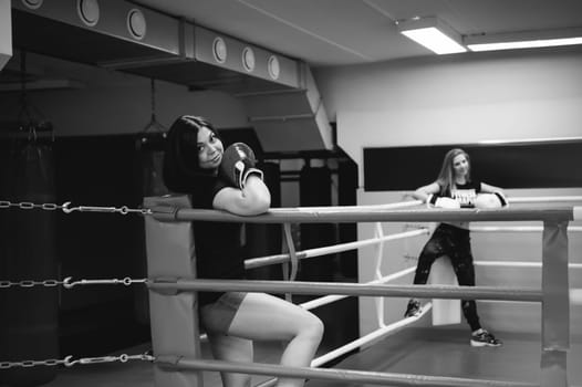 two young woman in boxing gloves In different corners of the boxing ring