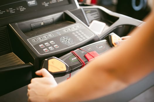 young woman is engaged fitness in gym. Performs cardio load on treadmill, running and walking with acceleration. sport, fit, lifestyle, technology and people concept