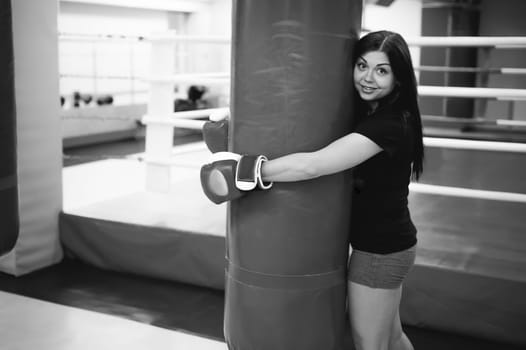 Young woman exercising in the gym on punching bag