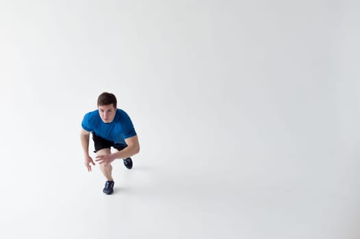 Running man on low start. Stands in rack, ready to achieve goals and wins. Young sexy Muscular male athlete wearing sporty blue t-shirt and shorts, studio portrait white background.Motivation concept