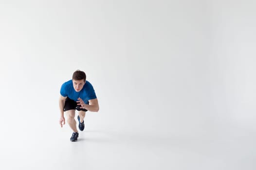 Running man on low start. Stands in rack, ready to achieve goals and wins. Young sexy Muscular male athlete wearing sporty blue t-shirt and shorts, studio portrait white background.Motivation concept