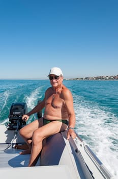Senior man driving an inflatable boat in Italy