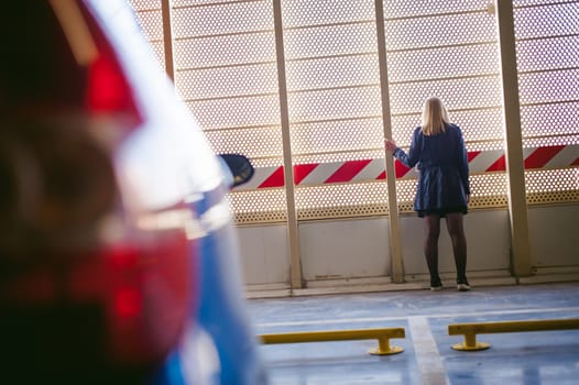 Woman in parking lot on blue car background