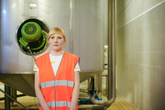 Female worker on beer factory. portrait woman in robe, standing on background line Food production, Inspection management control Equipment for production and bottling finish product end-user buyer