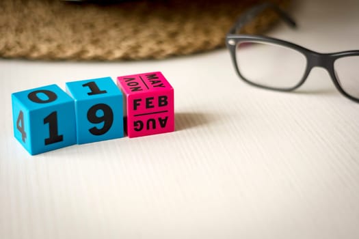modern perpetual calendar composed of colored cubes and set at the date of February 19th
