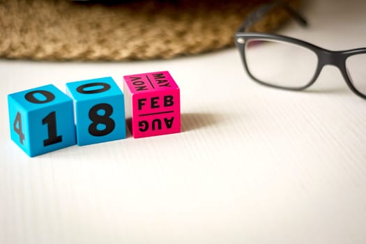 modern perpetual calendar composed of colored cubes and set at the date of February 18th