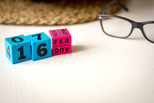 modern perpetual calendar composed of colored cubes and set at the date of February 16th