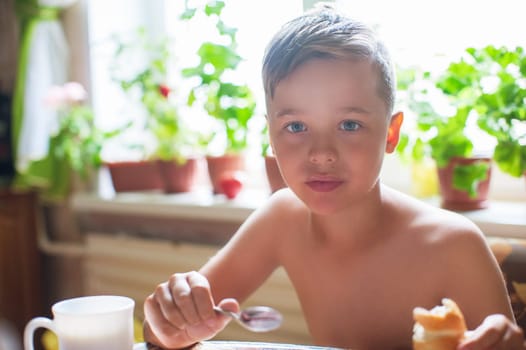Cute boy ready for breakfast in the kitchen