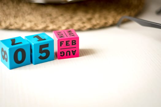 modern perpetual calendar composed of colored cubes and set at the date of February 5th