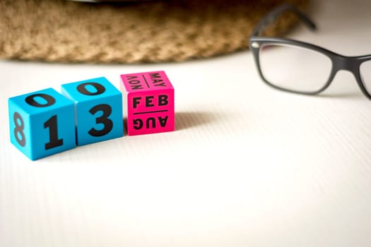 modern perpetual calendar composed of colored cubes and set at the date of February 13th