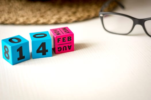 modern perpetual calendar composed of colored cubes and set at the date of February 14th