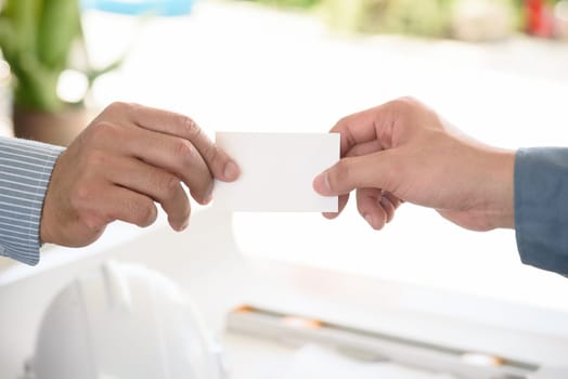exchanging business card with engineering tools background, selective focus