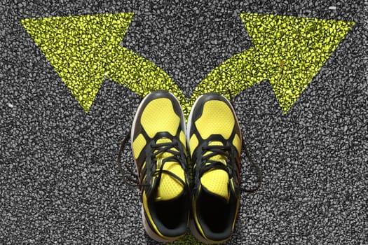 Sport shoes and arrows on asphalt