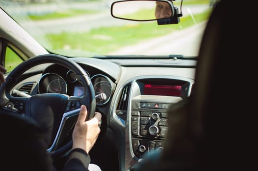 young bearded man driving a car, inside cabin rides, looking at road, driving, holding steering wheel.