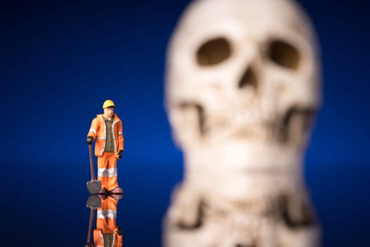 worker and blurry skull isolated om blue black background