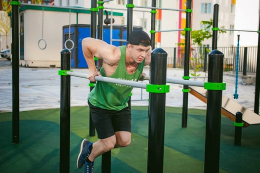 Handsome sexy male bodybuilder athlete man doing crossfit workout in athletic facilities on sunny morning outdoors. Healthy lifestyle concept. Physical preparation of the body