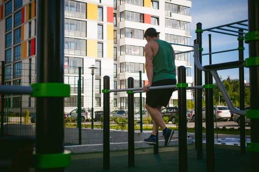 Handsome sexy male bodybuilder athlete man doing crossfit workout in athletic facilities on sunny morning outdoors. Healthy lifestyle concept. Physical preparation of the body