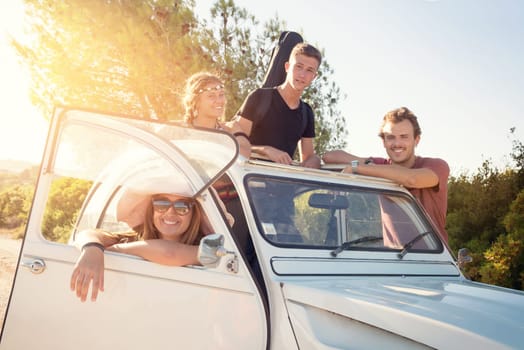 Group of happy people near a car in summertime, retro style.
