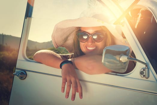 Girl posing in a car in sunset during vacations