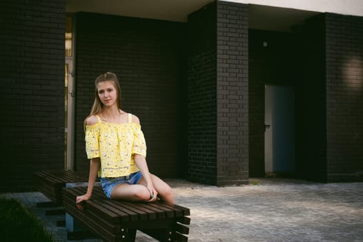 pretty cute young woman posing against the wall of black brick