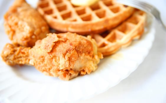 Belgian waffles and fried chicken on a white platter with copy space