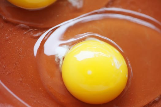 Overhead closeup of raw eggs on a brown background