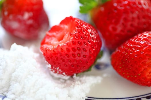 Fresh strawberries to dip in pile of powdered sugar, bite taken
