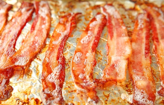 Just removed from the oven, bacon continues to sizzle in the pan.
