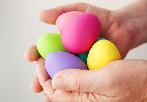 A man holding several colored Easter eggs