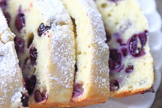 Loaf cake slices with blueberries and powdered sugar from overhead