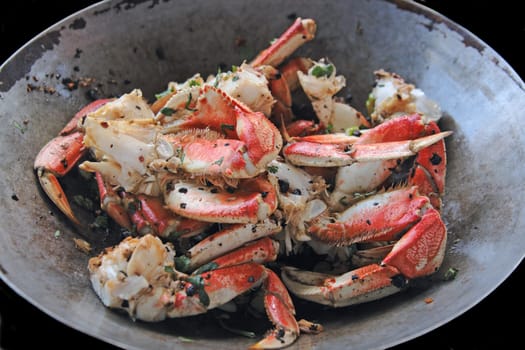 Dungeness crab cooked in a wok with black bean sauce, garlic and cilantro