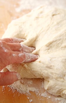 Fingers covered in flour and dough with bread dough