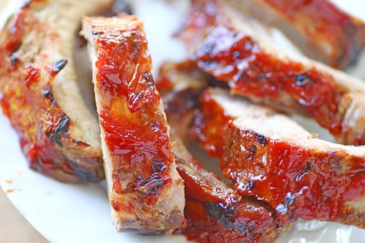 closeup of oven-barbecued baby back ribs glazed with a ketchup-based sauce