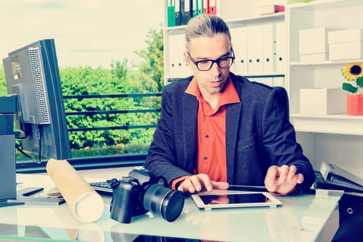 young reporter working in editorial office with tablet computer