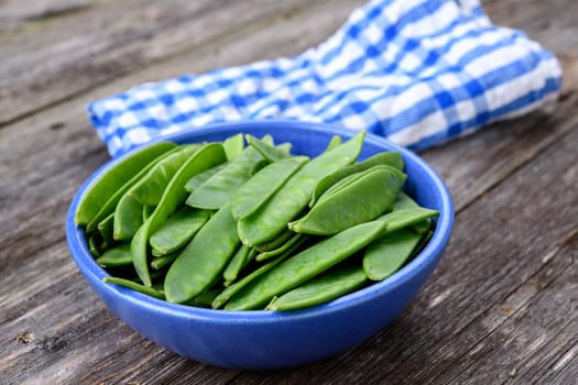 blue bowl with green peapods and towel