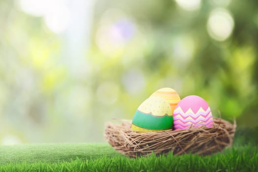 Basket of colorful easter eggs on the green grass