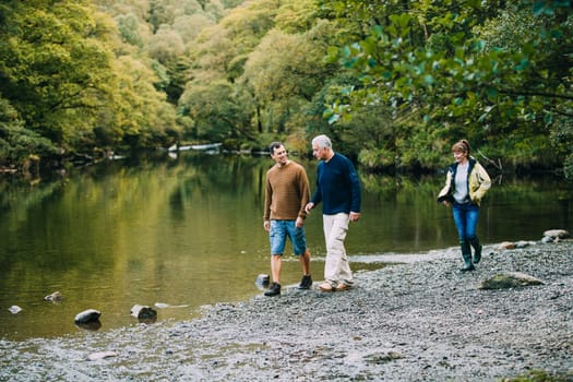 Mid adult man is enjoying a walk around the Lake District with his parents. He is walking with his father and his mother is just behind them.
