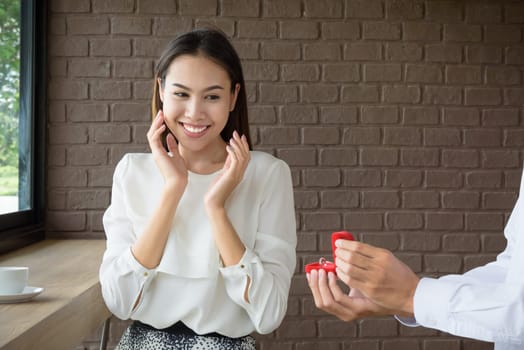 Man holding wedding ring to surprise woman, love and valentine concept