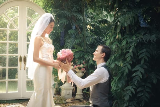man stand on knee with flower make a proposal to get married to beautiful girlfriend, engagement concept