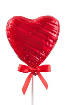 Red Chocolate love heart lollypop with a red ribbon bow on a stick. Isolated on a white background
