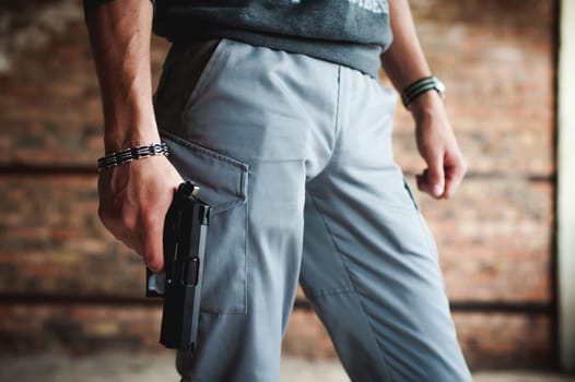 athletic man holding a gun in his hand on the ready