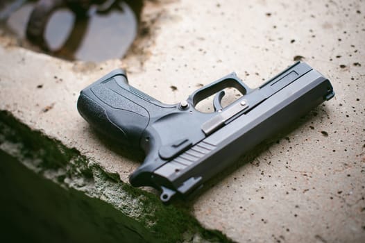 Black gun lying on the concrete