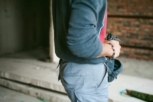 man pulls a gun out of his bag, holding it in his hand