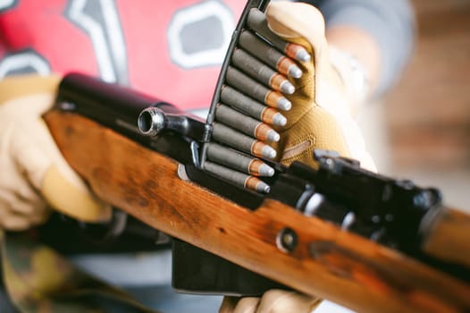 rifle carbine is weapon in hands. closeup tactical gloves  weapons, reloading ammunition. Soldier on a position performing a combat mission